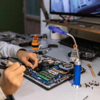 A laptop or desktop opened on a clean workbench, with screwdrivers, diagnostic tools, and parts nearby.